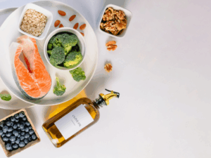 Alimentos antiinflamatorios como salmón, aceite de oliva, frutos secos, avena, brócoli y arándanos para reducir la inflamación silenciosa.